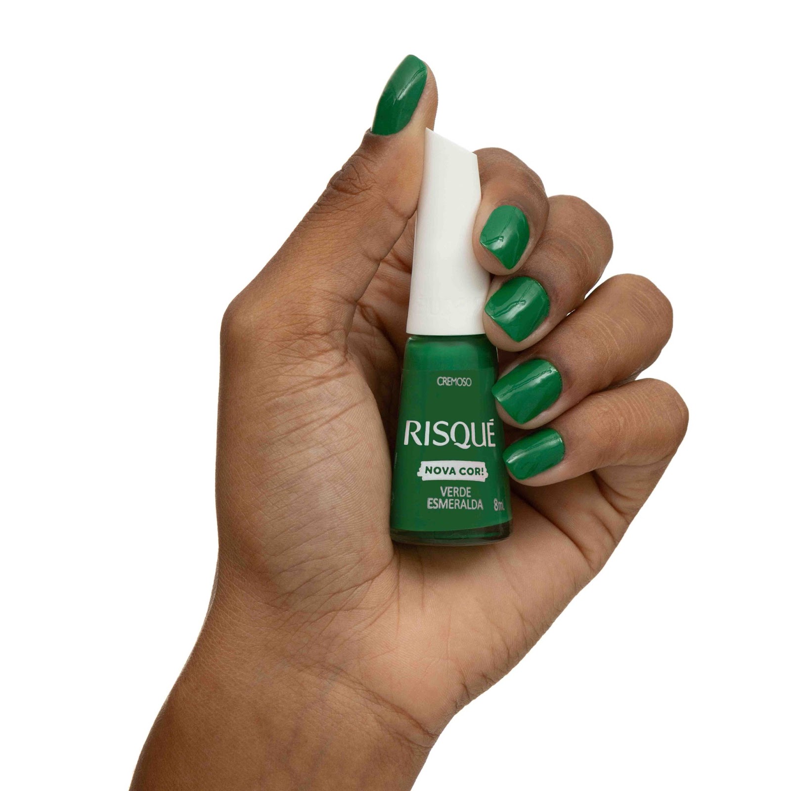 Uma mulher com as unhas pintadas de verde segura o esmalte Risqué Verde Esmeralda.