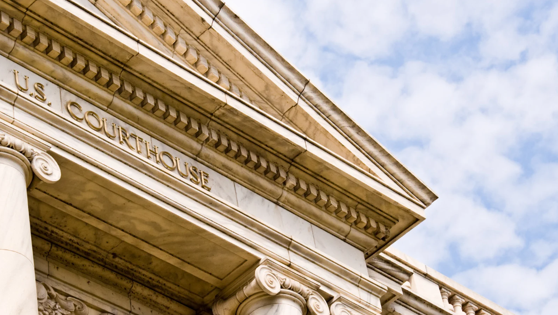 (Exterior of a U.S. Courthouse building with classical architecture, representing the legal system and civil rights litigation.)