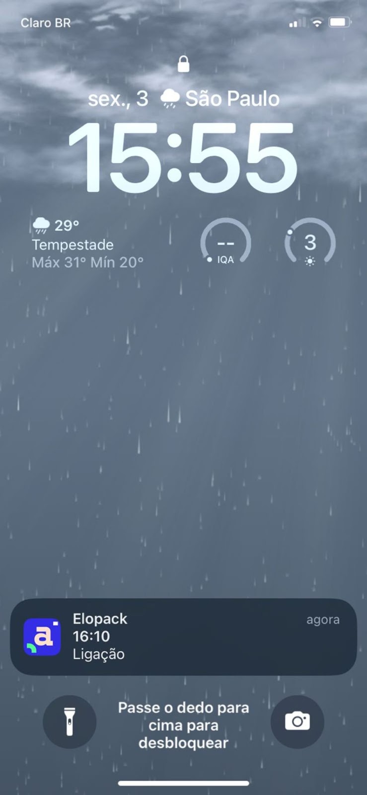 Tela de bloqueio de smartphone com notificação de chamada e visualização do clima em São Paulo, mostrando um dia chuvoso. Ilustra o uso de um aplicativo de calendário e agenda em tempo real, com foco na organização da rotina e acompanhamento de compromissos pelo celular. o Aplicativo em questão é o Agendor, CRM de vendas.