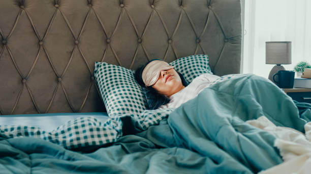 A woman sleeping in a cozy bed, symbolizing the importance of restorative sleep for hormonal health and overall wellbeing.