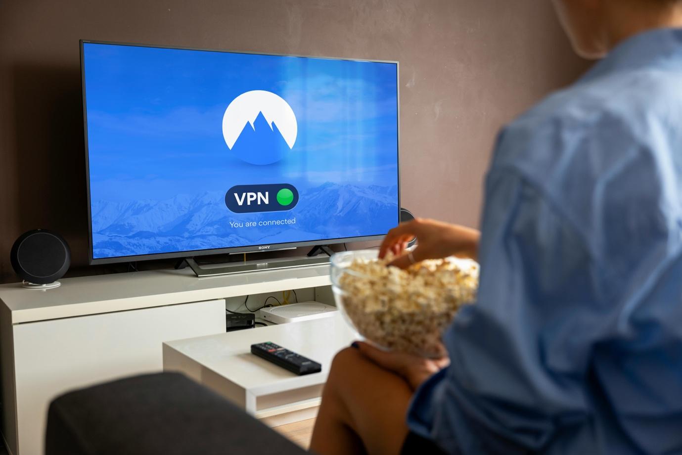 A person eating popcorn while watching a tv

Description automatically generated