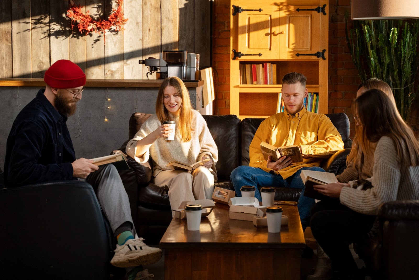 Friends sharing a moment of relaxation in a chalet in Val-David, with books and cafes
