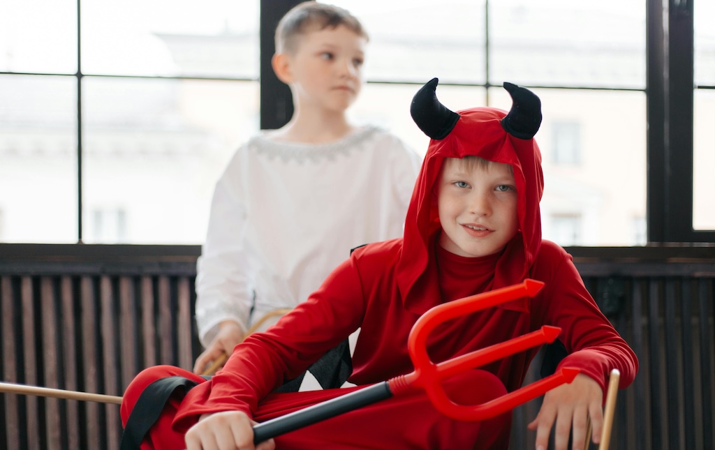 young boy sitting in devil costume