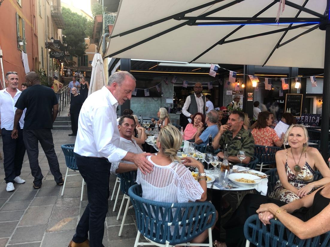 A group of people sitting at a table outside

Description automatically generated