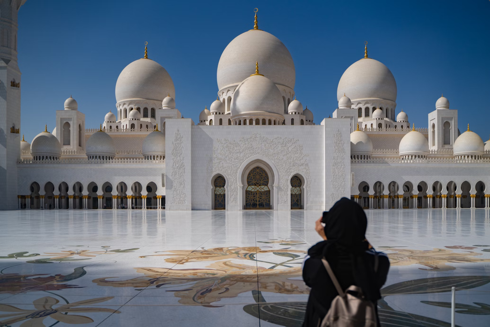 A female tourist wearing an Abaya and a headscarf at a tourist site - (Credits Unsplash)