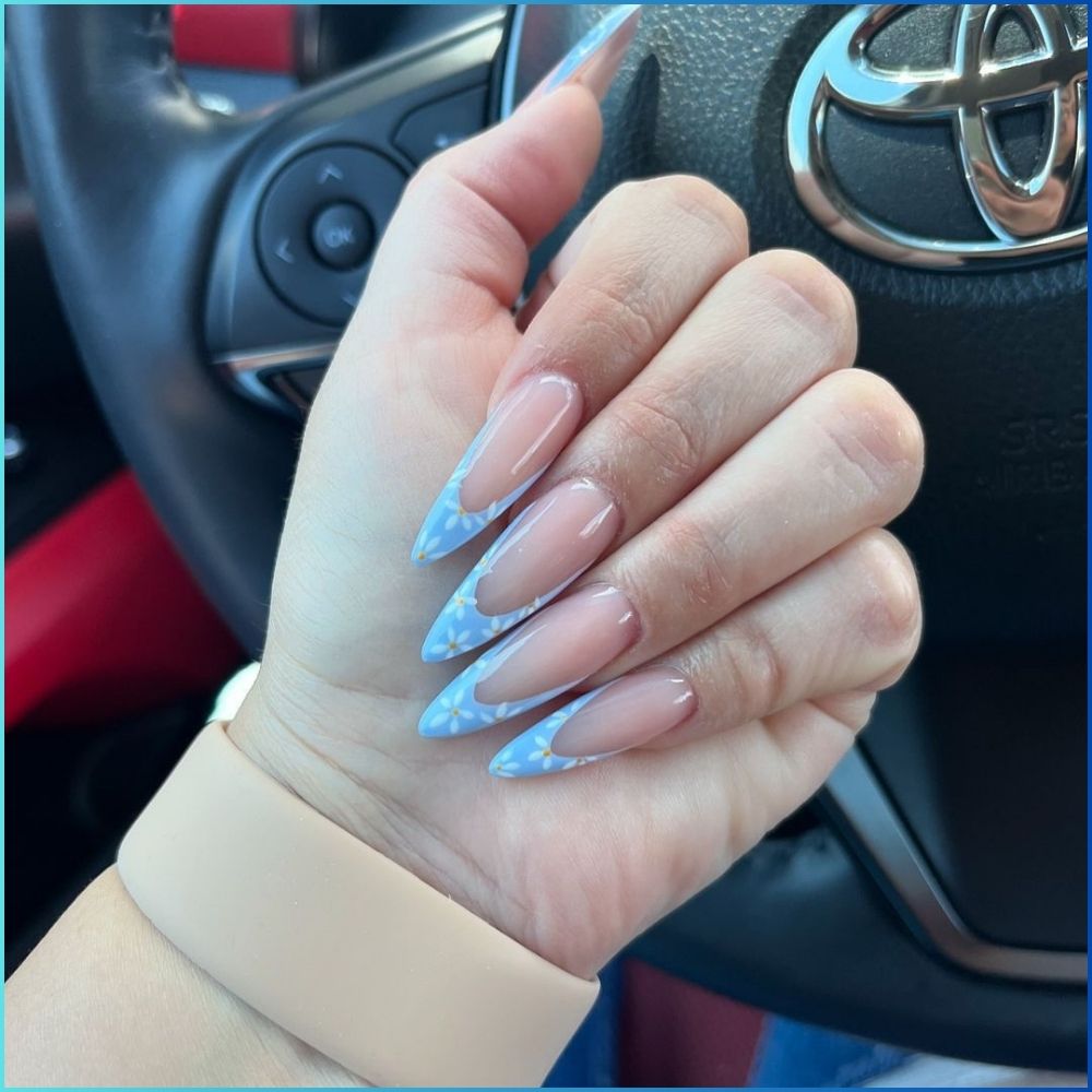 Close up of hands with flowered designed blue nails having Long Stilettos