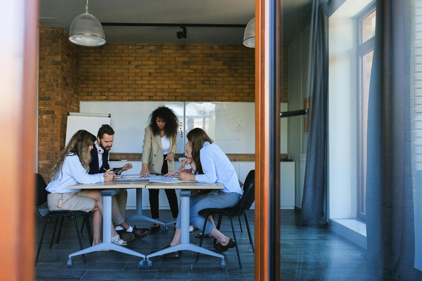 A group of people discussing and working together at a table in a meeting room.