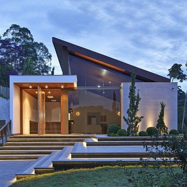 Gambar rumah modern dengan atap pelana asimetris, sisi miring tidak sama panjang, menciptakan kesan unik dan artistik.