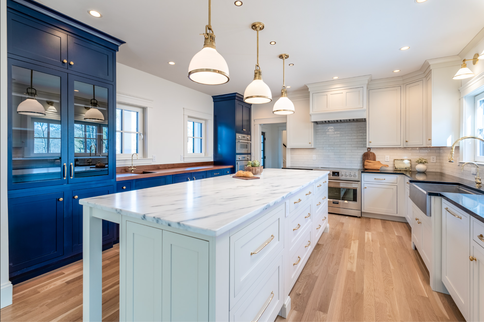 This image depicts a kitchen featuring sleek inset cabinets with a clean, minimalist design. The cabinets are finished in a soft white hue.