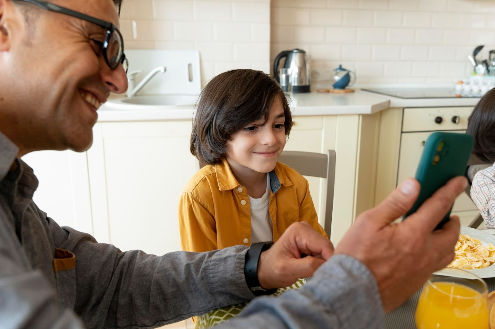 father son looking in smartphone at home.