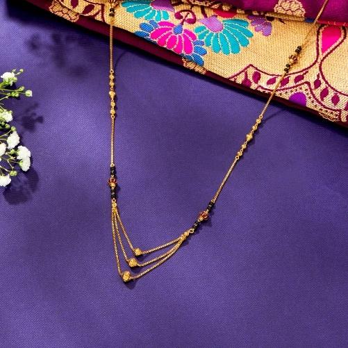 A gold necklace on a purple surface

AI-generated content may be incorrect.