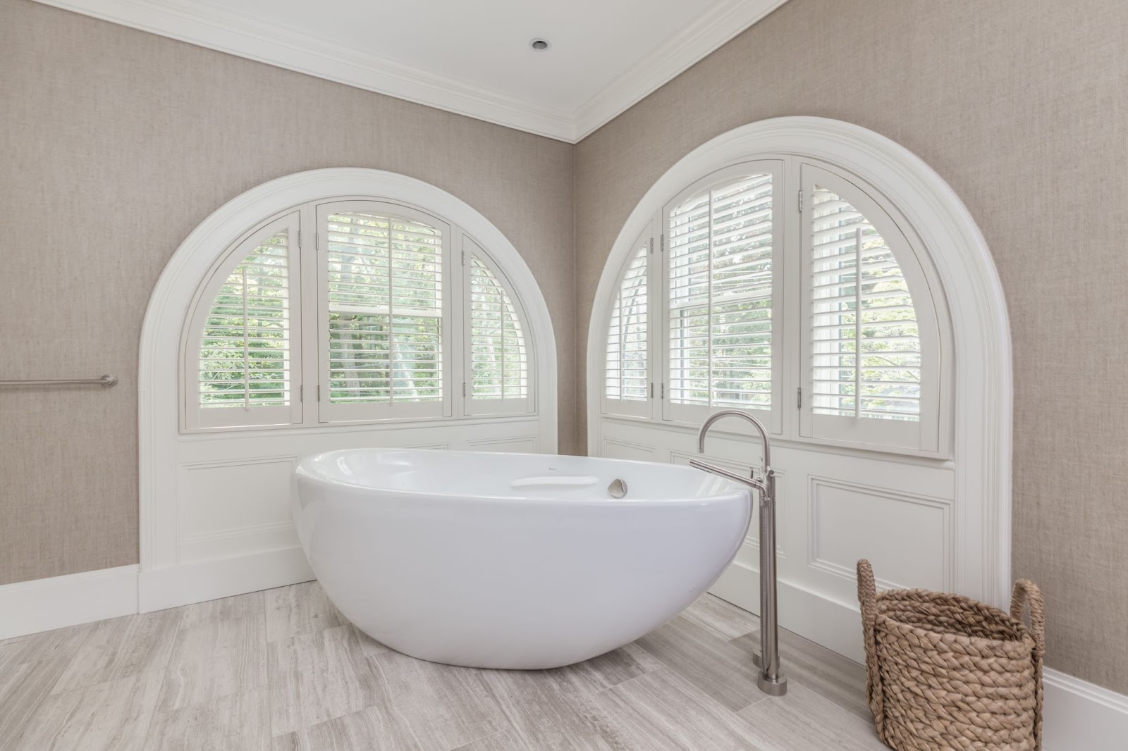 Elegant bathroom with a freestanding tub and arched windows