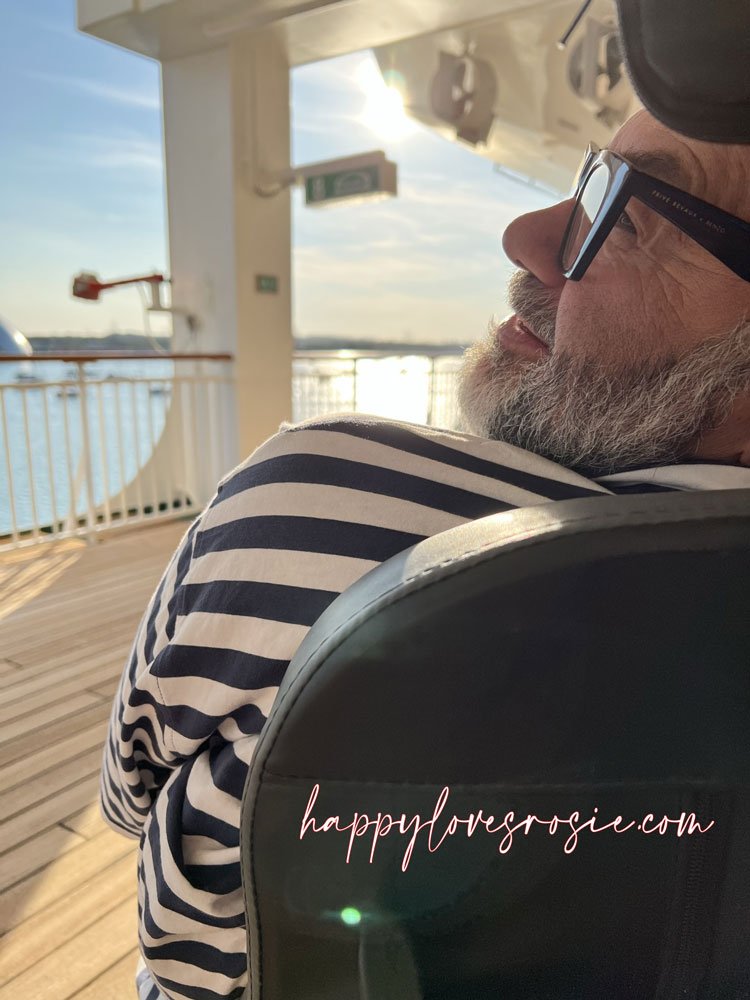 man sitting in wheelchair on the deck of a ship