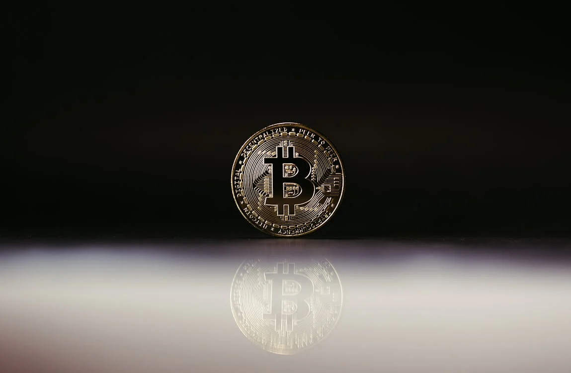 Golden Bitcoin coin with black background symbolizing cryptocurrency investment and market trends