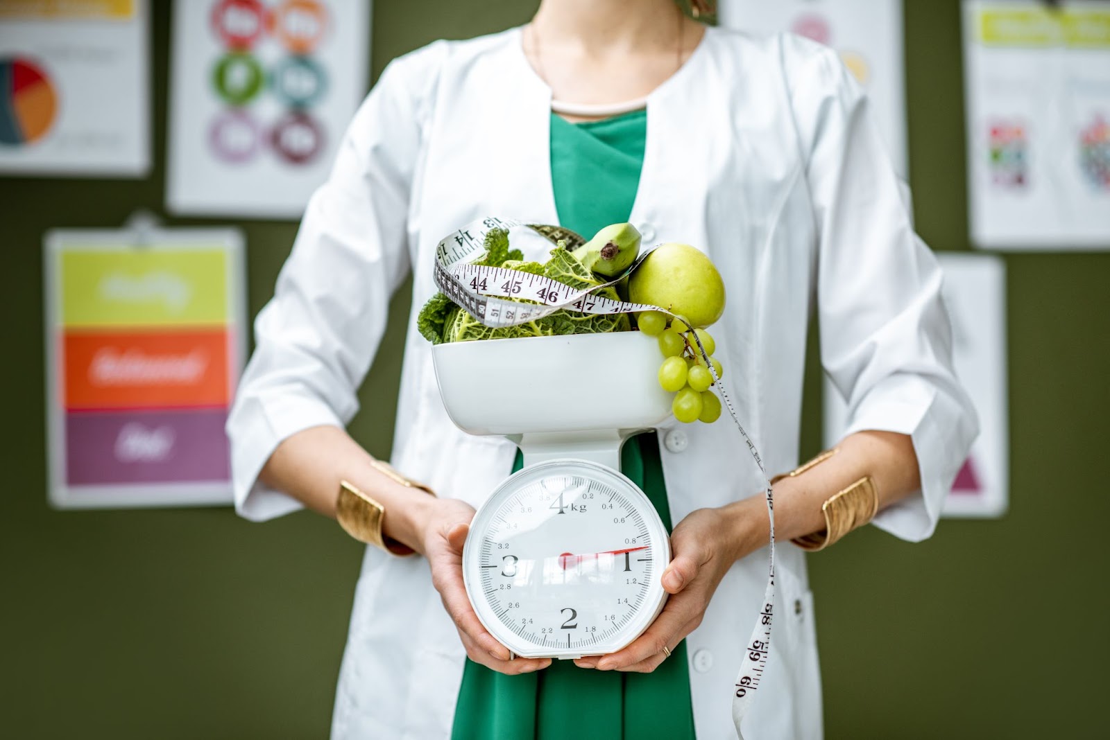 A nutritionist holding healthy food on a weighing scale, with colorful charts in the background for healthy weight loss.