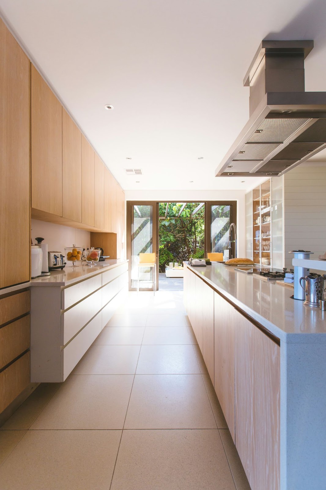 A view from inside a house looking down a long kitchen.