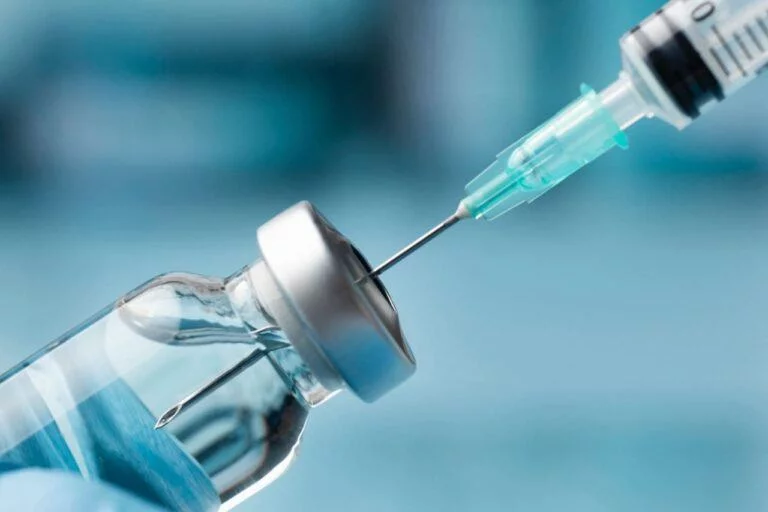 close-up-of-syringe-needle-inserting-into-vial-with-clear-liquid-against-blue-background-why-cortagen-is-the-biohackers-answer-to-long-covid-and-systemic-inflammation-tony-huge