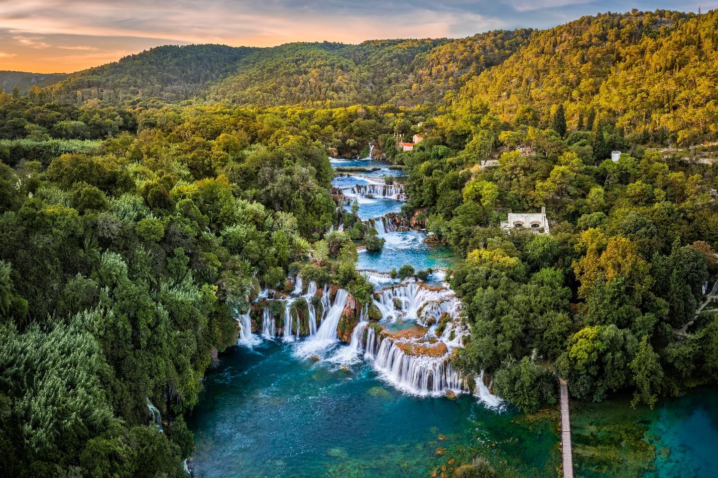 A waterfall surrounded by trees

AI-generated content may be incorrect.