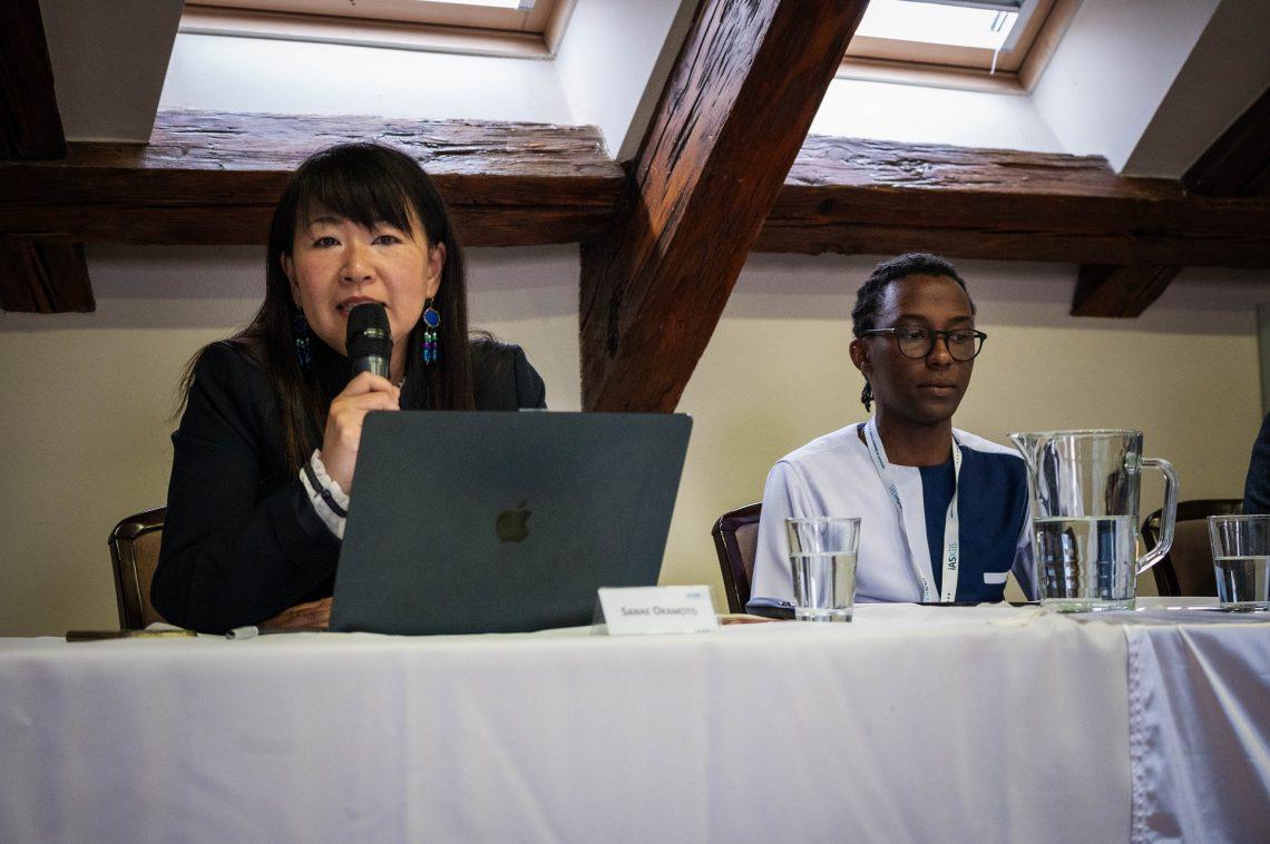 A person speaking into a microphone with a person sitting at a table

AI-generated content may be incorrect.