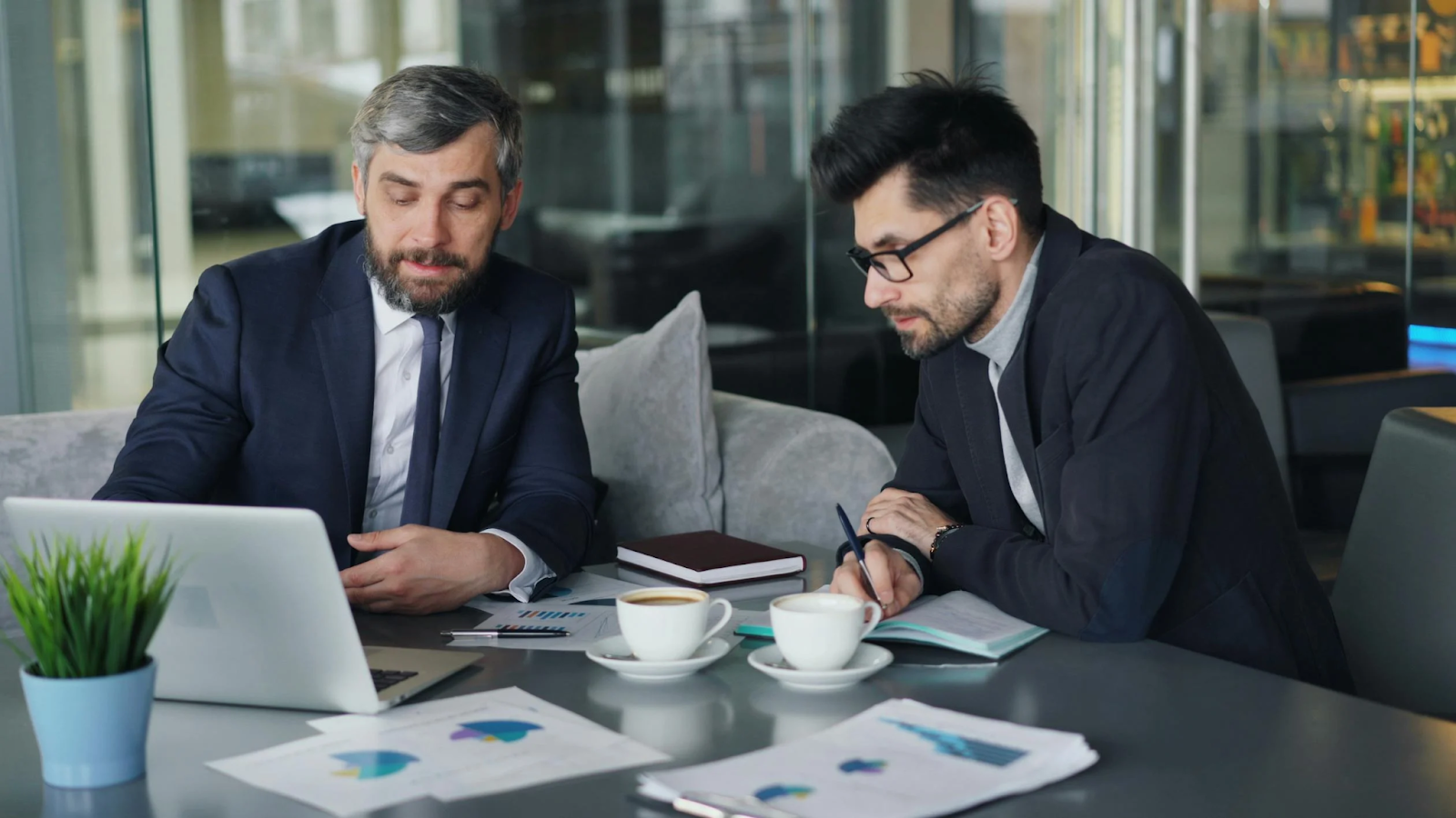 Two men discussing business over coffee