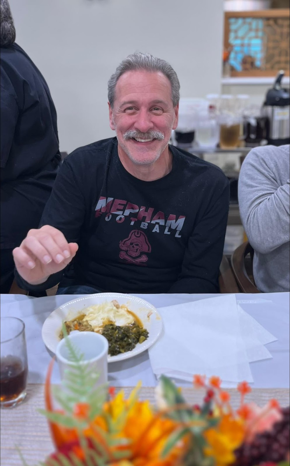 A smiling resident in a memory care community enjoying Thanksgiving dinner