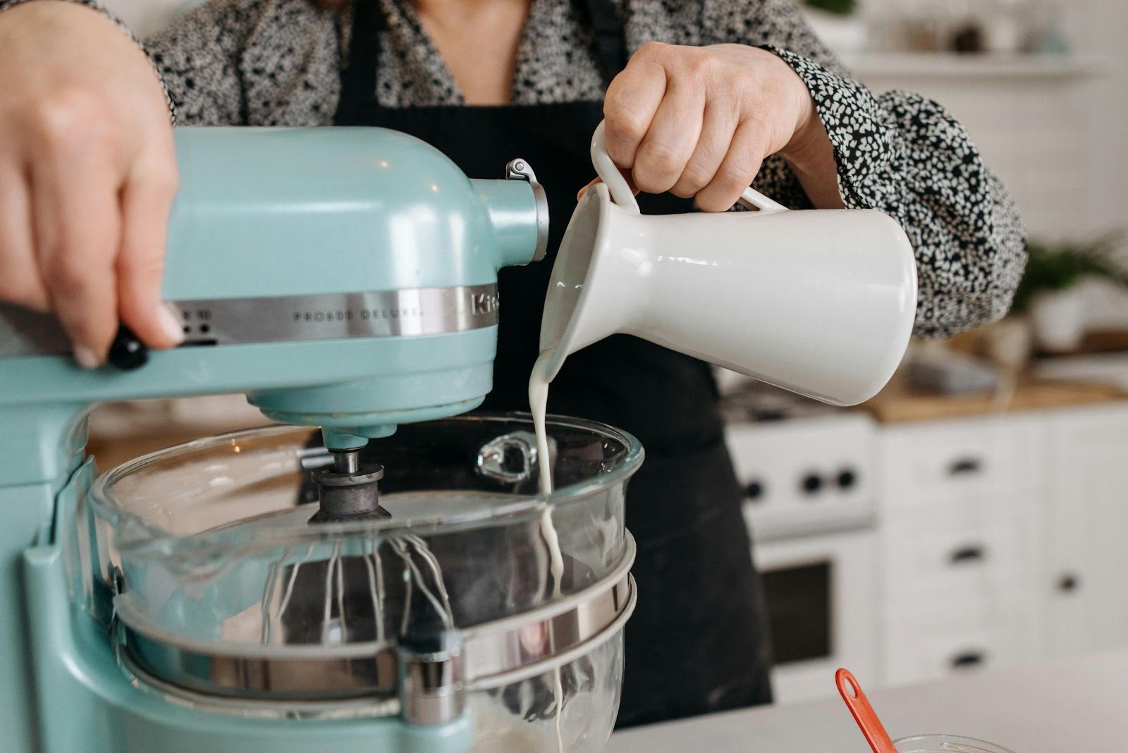 A mixer while a person is adding milk