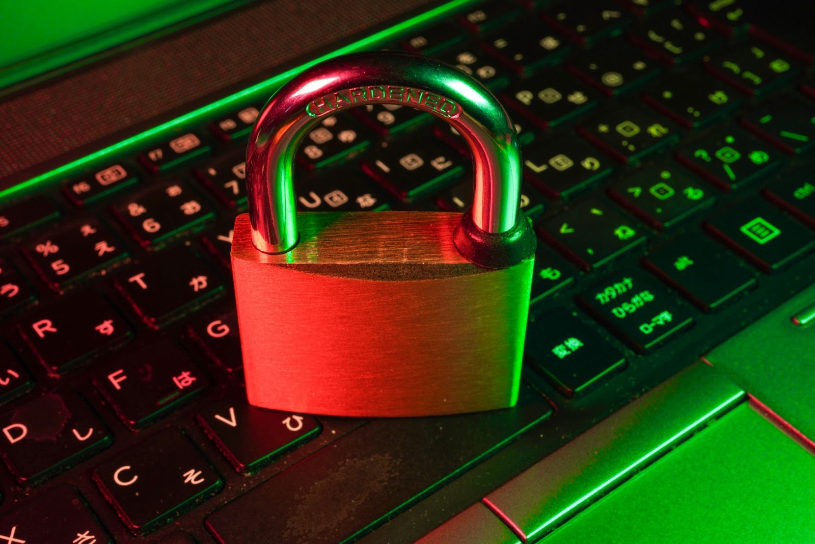 A lock placed on a keyboard, illuminated with contrasting red and green lighting.
