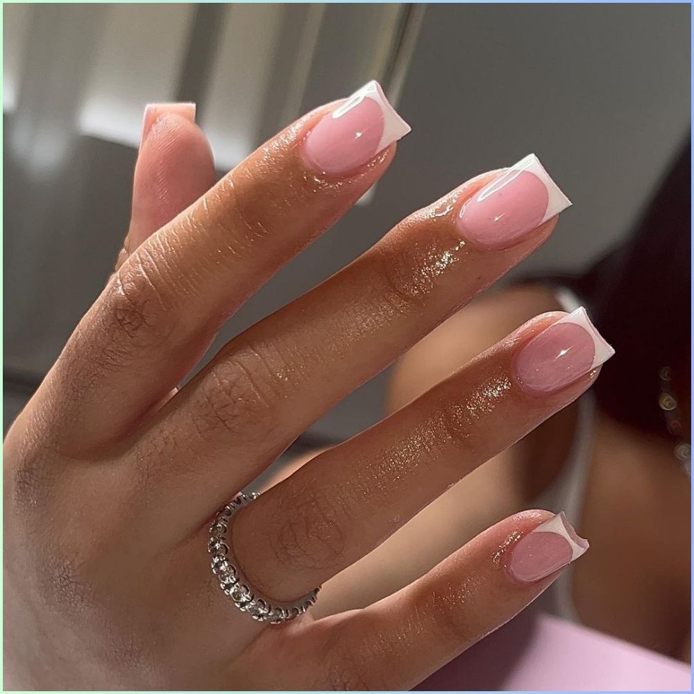 Zoom in view of hand with simple French tip nail having Simple white French tips