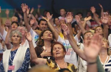 A group of people raising their hands

Description automatically generated