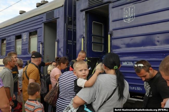 Матір тримає на руках дитину перед посадкою&nbsp; в евакуаційний потяг. 21 серпня Міністерство реінтеграції ТОТ України запровадило примусову евакуацію дітей із батьками з&nbsp;Покровського району Донеччини саме через просування російських військ в цьому районі