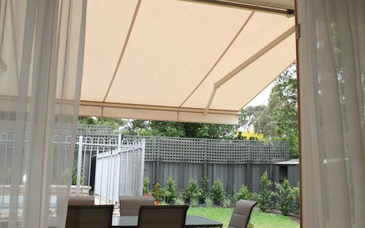 White folding arm awning used in the garden