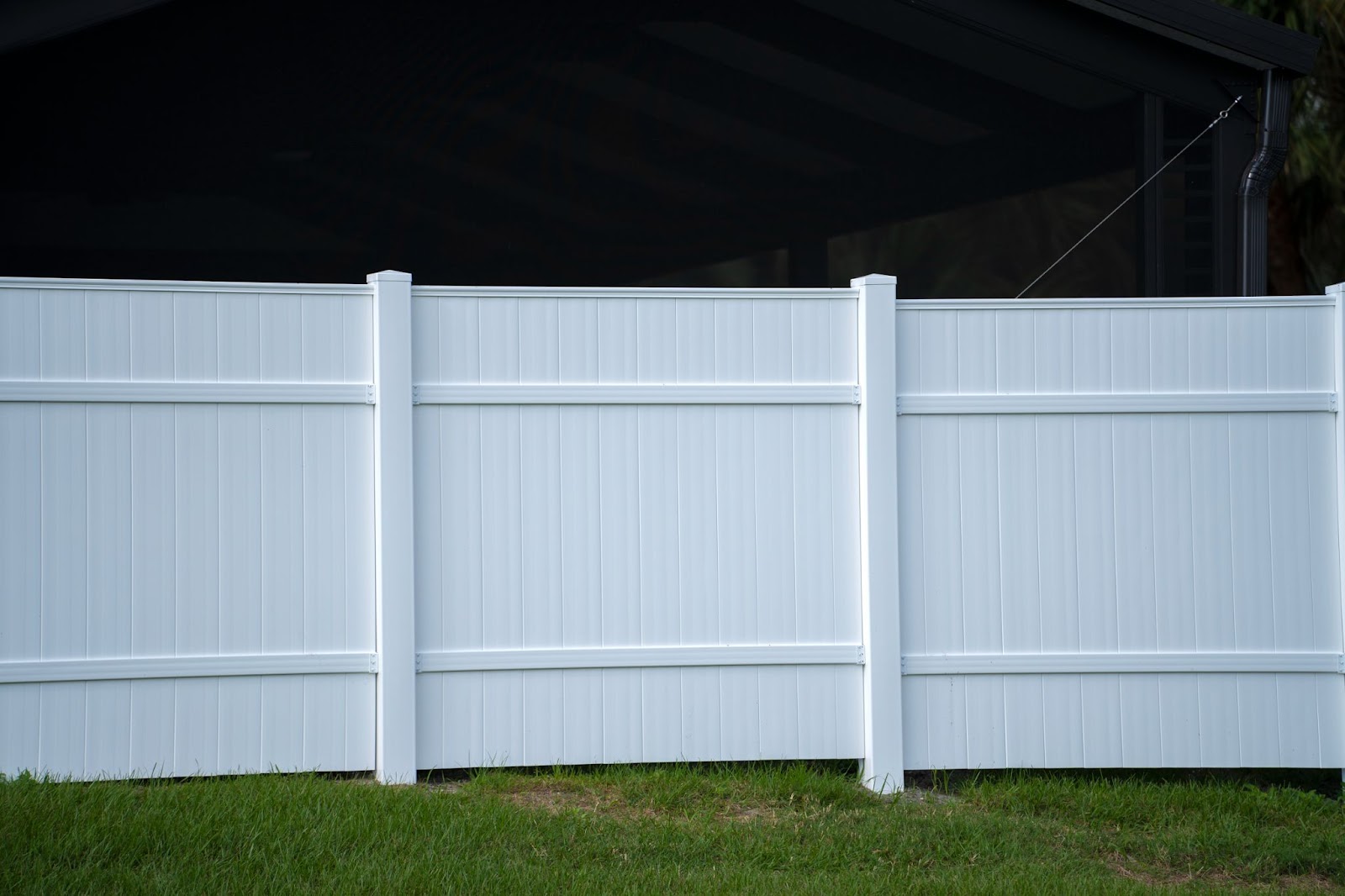 White vinyl fence next to grass.  