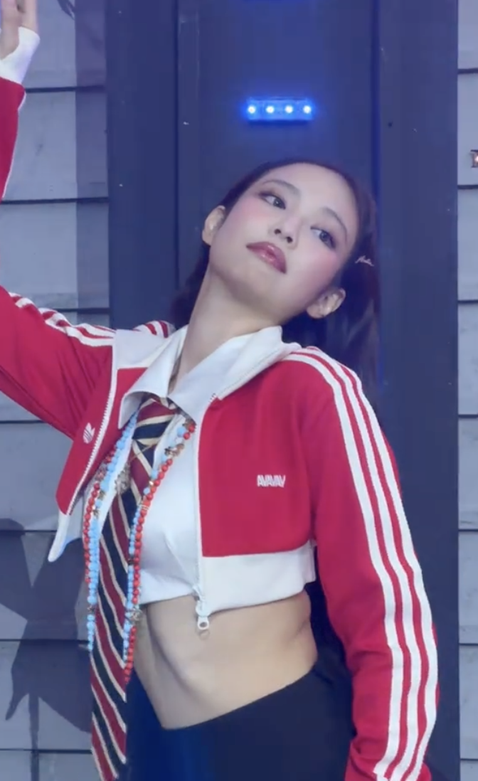 A picture of BLACKPINK Jennie on a red jacket with a white strip and a white shirt 