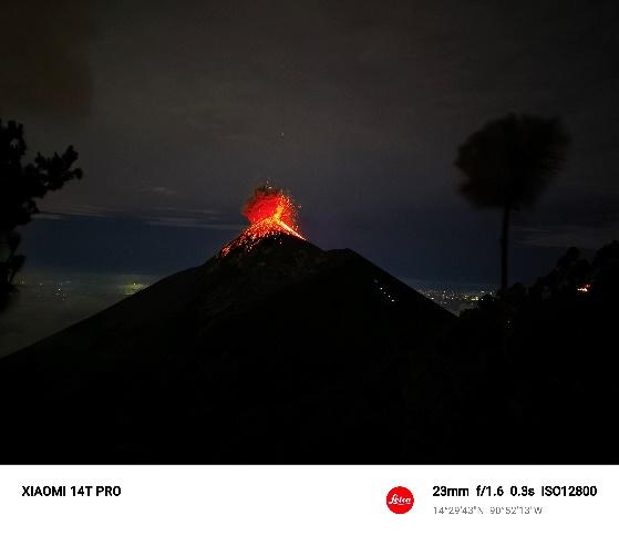 A volcano erupting at night

Description automatically generated