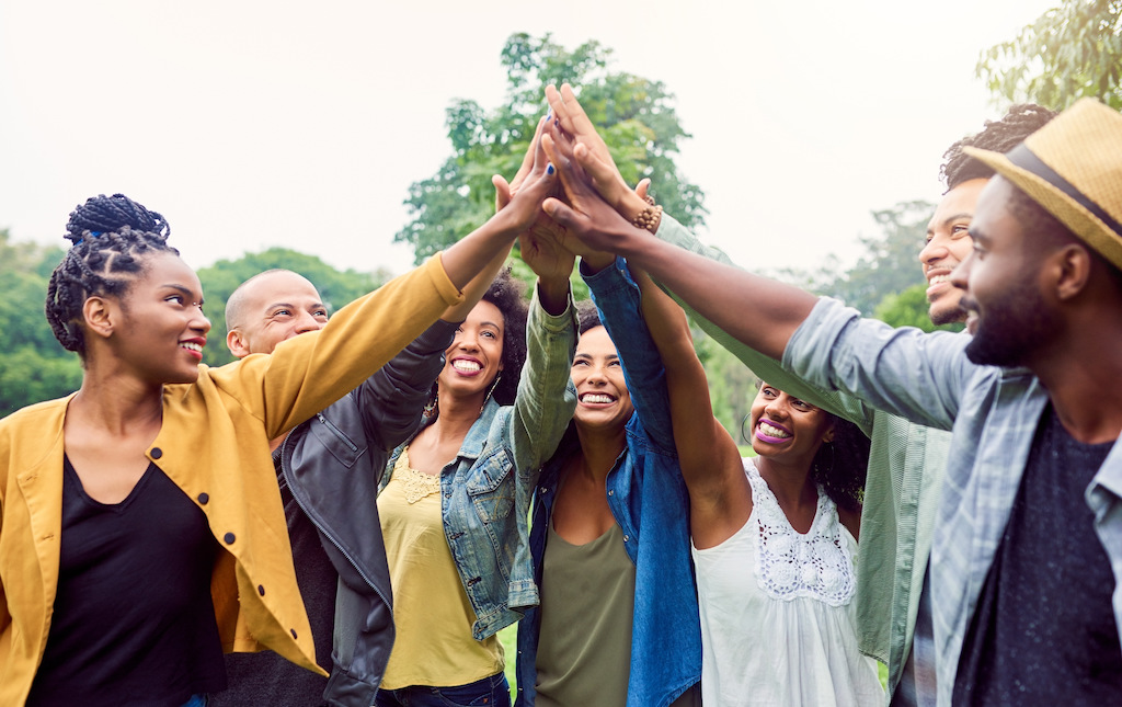 Organizers, volunteers and sponsors high-fiving at a fundraising event