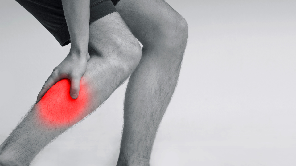 Man grabbing his calf because of pain.