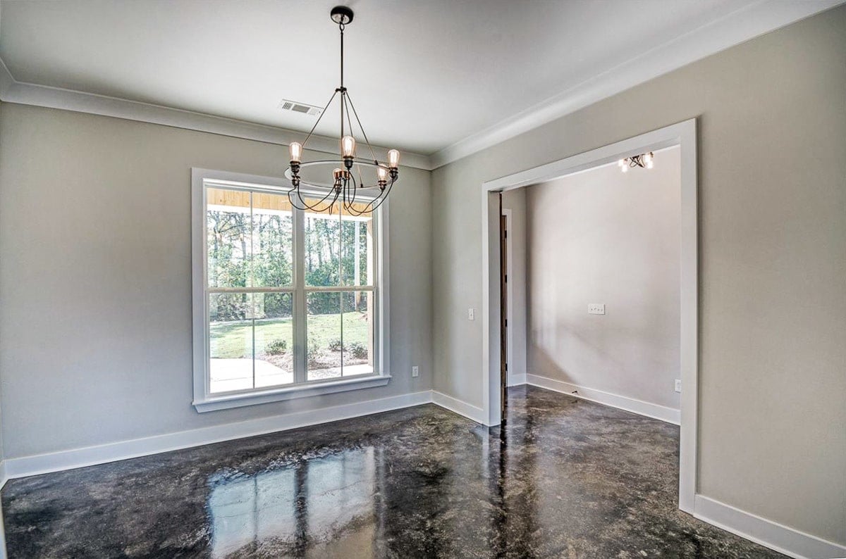 The formal dining space has gray walls, a white framed window, and a bulb chandelier.