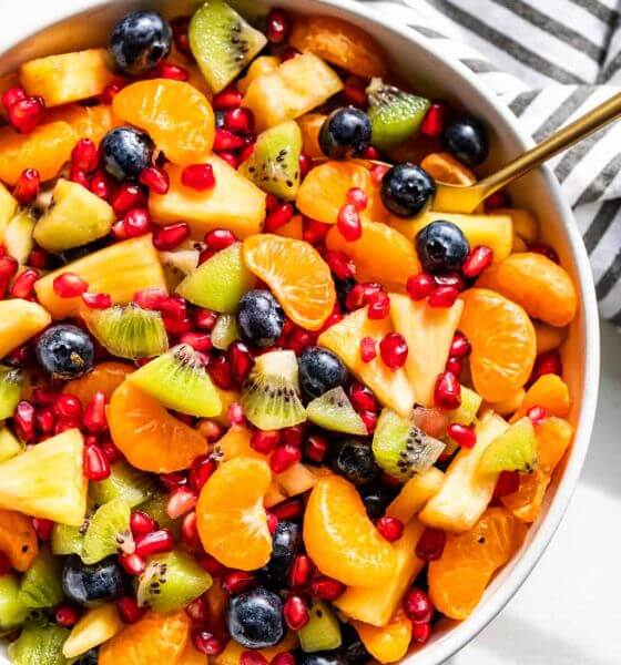 Winter fruit salad with oranges, blueberries and kiwi in a white bowl