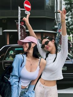 This  contain an image of  Natty and Ningning standing next to each other in front of a car holding up signs