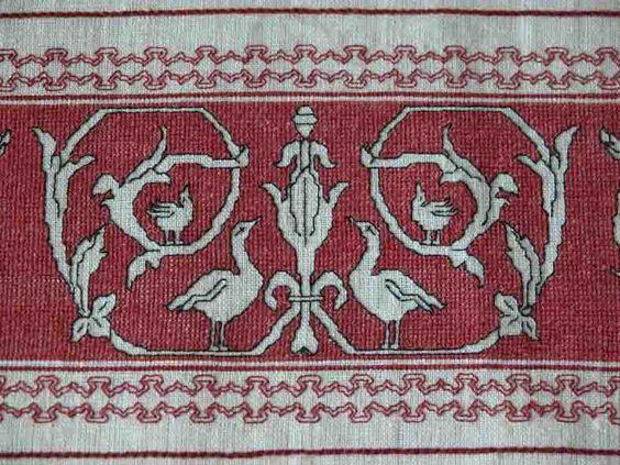 A red and white embroidered rug

Description automatically generated