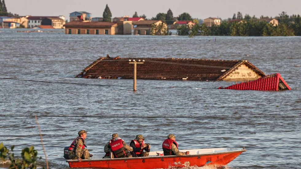 Cette photo prise le 7 juillet 2024 montre des secouristes sur un bateau devant le toit dune maison inonde lors dune inondation cause par une rupture de barrage dans le lac Dongting, dans le comt de Huarong, dans la province centrale du Hunan en Chine. 
Photo dillustration