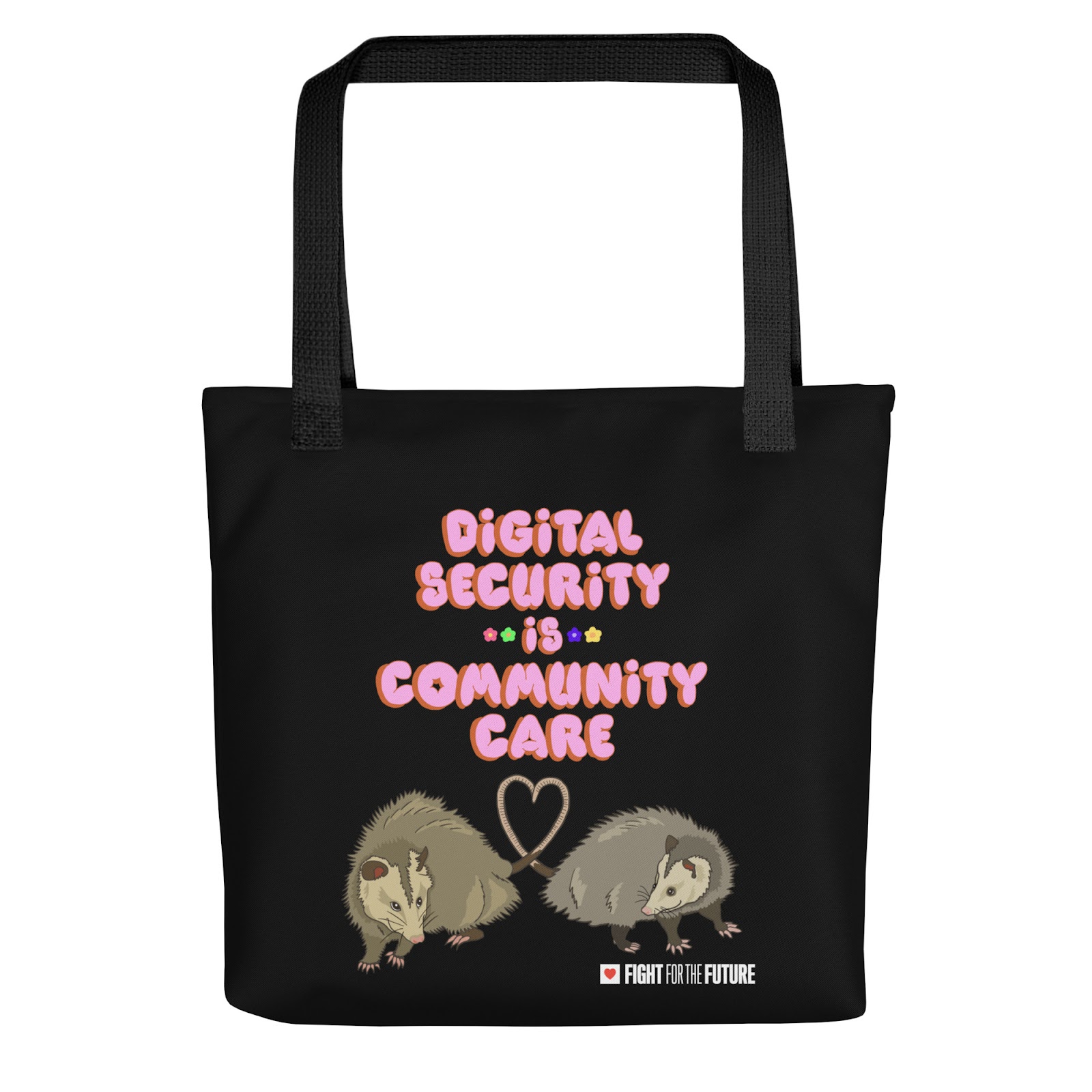 A black tote bag with pink bubble letters reading "digital security is community care." Below, two possums form a heart with their tails. The Fight logo appears in the bottom right corner.