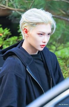 This contains an image of Stray Kids member Felix in black hoodie