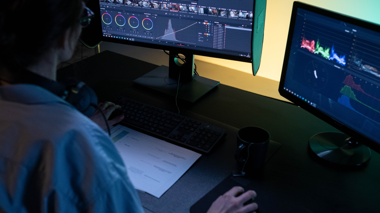 A video editor two monitors to color grade a video in DaVinci Resolve.