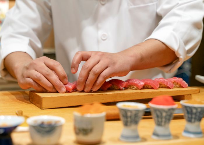 An expert chef preparing fresh nigiri sushi.