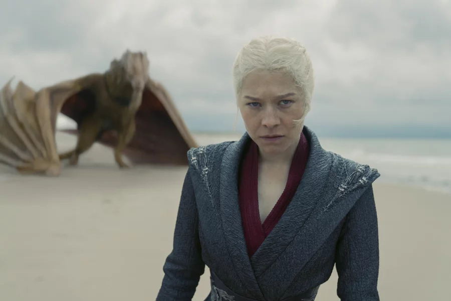 House of the Dragon temporada 2, con Rhaenyra (Emma D'Arcy) caminando en la costa y su dragón parado a varios metros de ella, por detrás. Su expresión es de rabia.