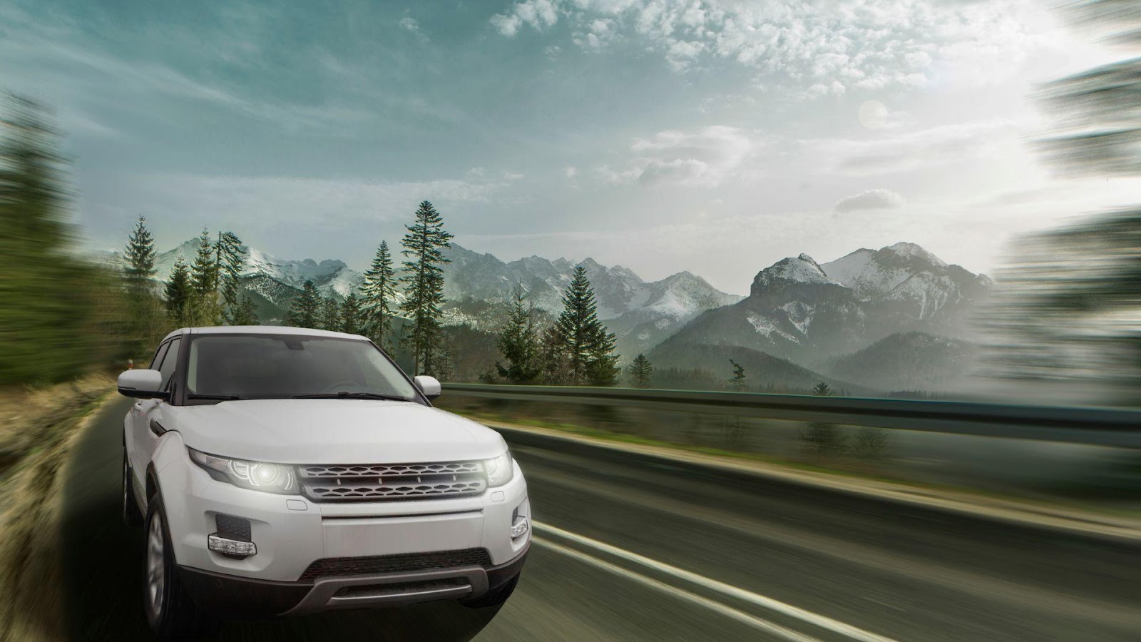 White SUV driving on a highway with a scenic mountain backdrop, showcasing unique car design.