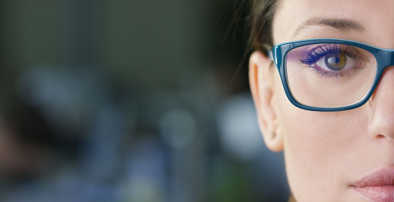 A close up of a young woman wearing her Neurolens glasses