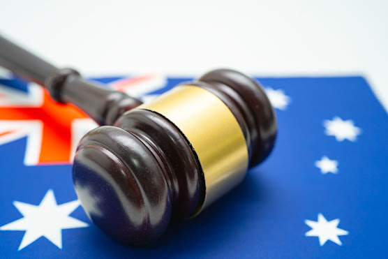 Representaion of a hammer used by the judge in the court room which is kept ove the national flag of Australia