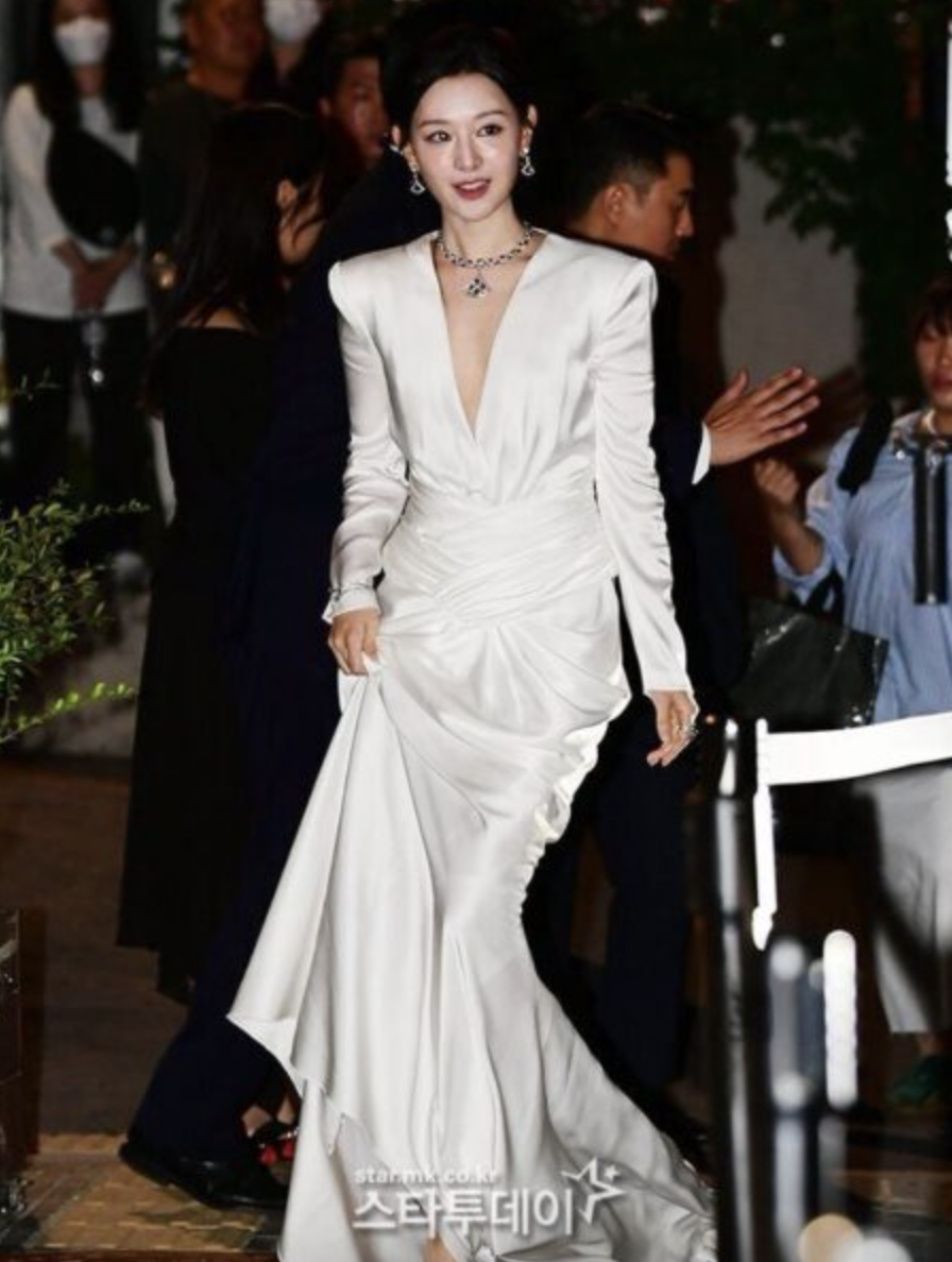 This contains an image of: Kim Ji Won on white dress with fans with sexy neckline